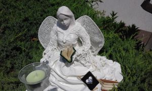 Rzeźba biały anioł z książką w ręku