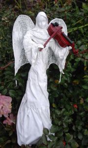 Rzeźba biały anioł grający na szkrzypcach